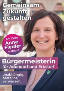 Wahlplakat: Anne Fiedler im Porträt vor dem Adendorfer Rathaus, Textband „Bürgermeisterin für Adendorf und Erbstorf.“, darunter „unabhängig, parteilos, verwurzelt.“
